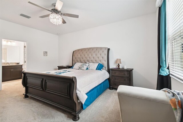 bedroom featuring ensuite bathroom, ceiling fan, and light colored carpet