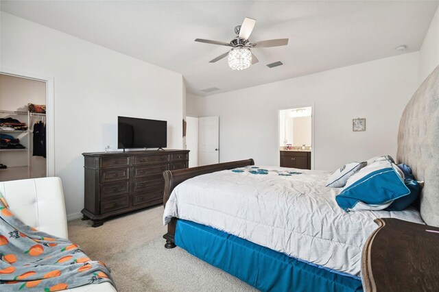 bedroom featuring connected bathroom, ceiling fan, a spacious closet, light colored carpet, and a closet