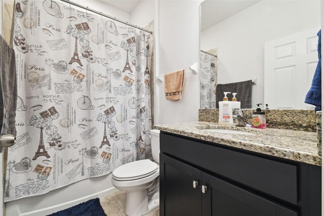 full bathroom with tile patterned flooring, shower / bath combo with shower curtain, toilet, and vanity