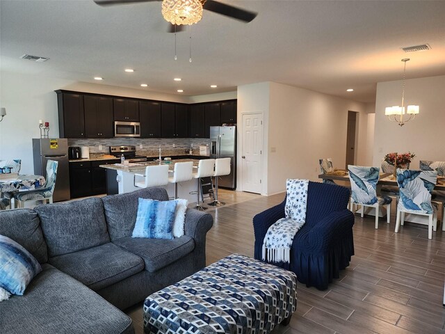 living room with sink, ceiling fan with notable chandelier, and hardwood / wood-style floors