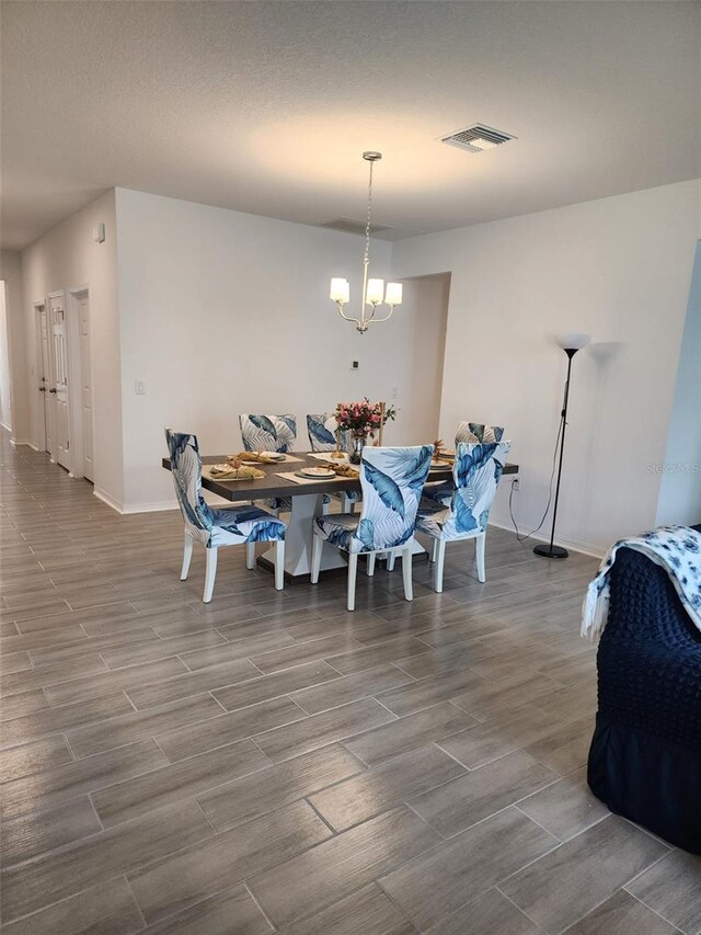 dining space with an inviting chandelier and wood-type flooring