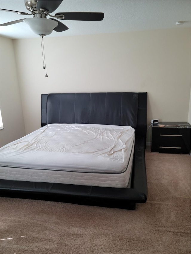 bedroom with dark colored carpet and ceiling fan