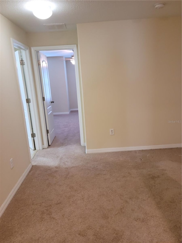 empty room with light colored carpet and ceiling fan