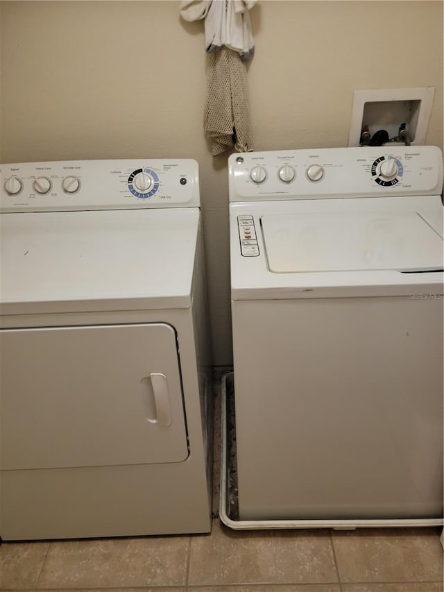 clothes washing area with light tile floors, independent washer and dryer, and hookup for a washing machine