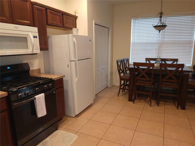 kitchen with white appliances, pendant lighting, and light tile floors