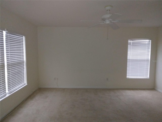 empty room with ceiling fan and light colored carpet