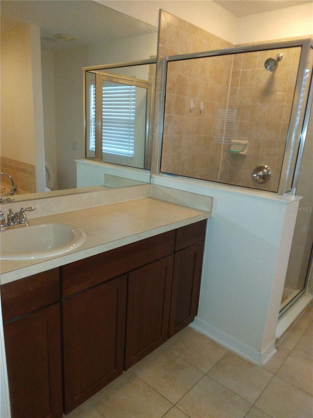 bathroom featuring a shower with door, large vanity, and tile floors