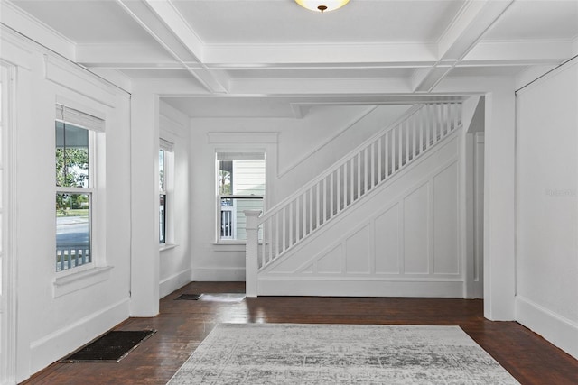 foyer entrance with coffered ceiling, beam ceiling, and dark wood-type flooring