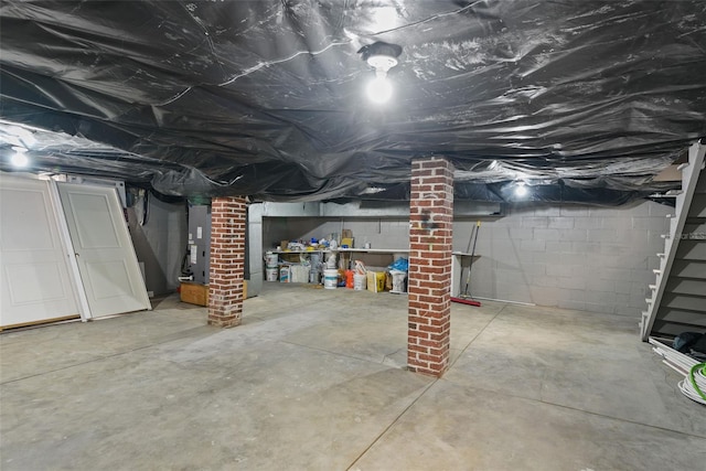 basement featuring brick wall and heating utilities