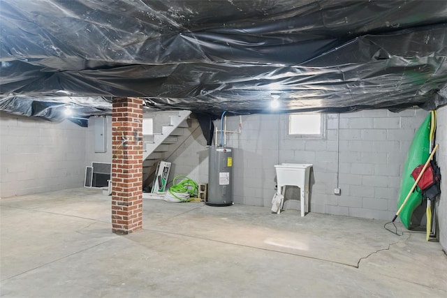 basement featuring electric water heater and sink