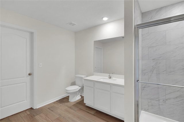 bathroom featuring a shower with door, toilet, oversized vanity, and hardwood / wood-style flooring