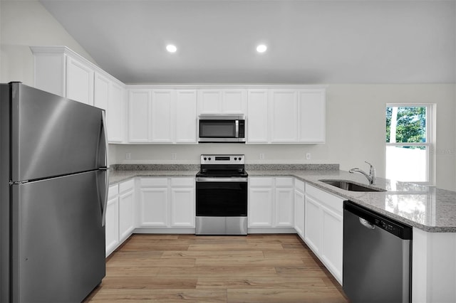 kitchen featuring kitchen peninsula, white cabinetry, sink, light hardwood / wood-style flooring, and stainless steel appliances