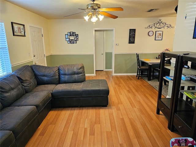 living room featuring light hardwood / wood-style flooring and ceiling fan