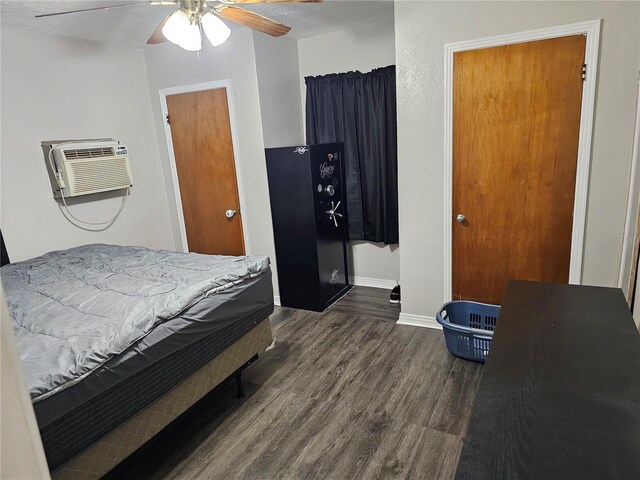 bedroom featuring dark wood-type flooring, ceiling fan, and a wall mounted AC