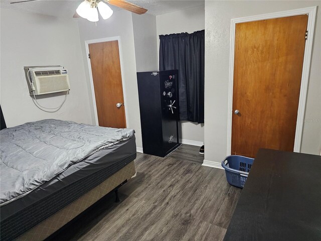 bedroom with ceiling fan, dark hardwood / wood-style floors, and an AC wall unit