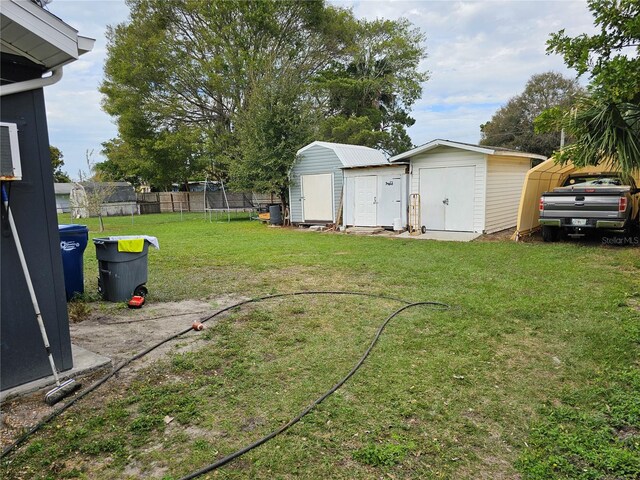 view of yard with a trampoline and a storage unit