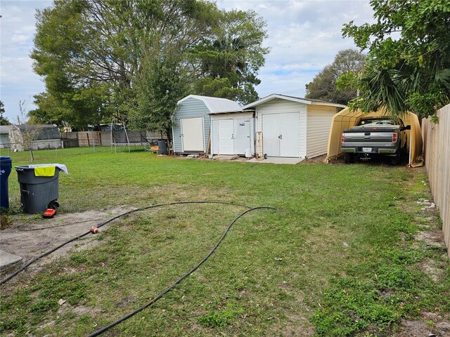 view of yard with a trampoline and a shed