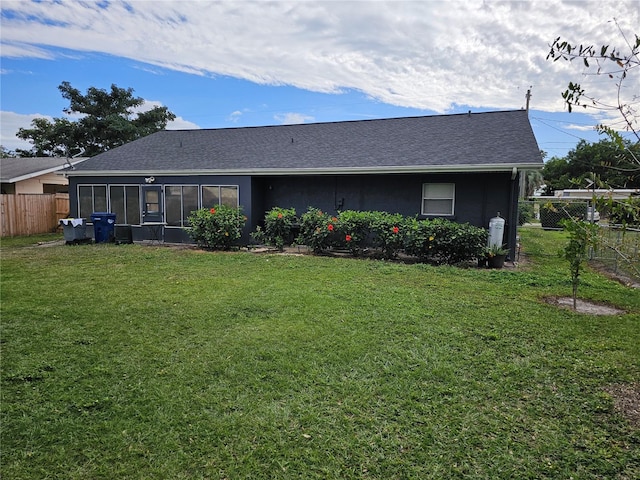 rear view of house featuring a lawn