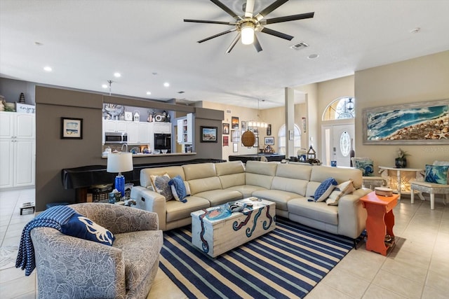 tiled living room featuring ceiling fan with notable chandelier