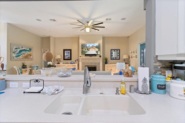 kitchen featuring white cabinetry, ceiling fan, and sink