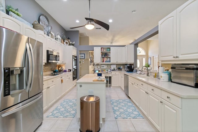 kitchen featuring light tile flooring, appliances with stainless steel finishes, and a center island