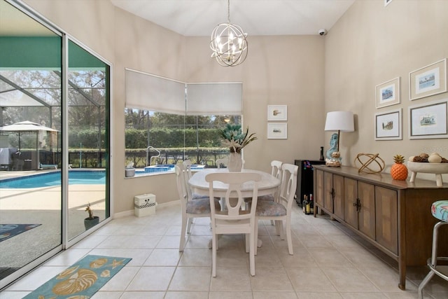 dining space with light tile flooring, a chandelier, and a towering ceiling