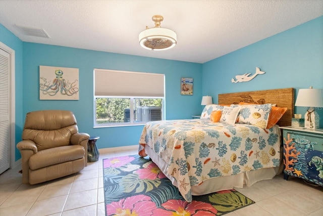 bedroom with a textured ceiling and light tile flooring