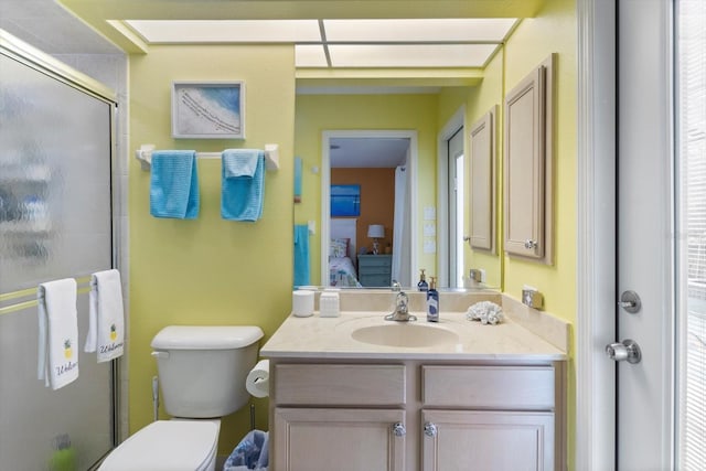 bathroom featuring toilet, an enclosed shower, and vanity