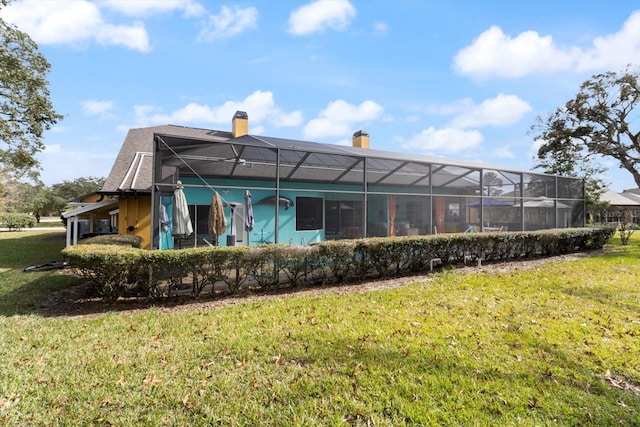 rear view of property with a lawn and a lanai