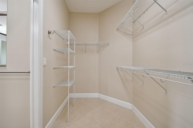 walk in closet with light tile patterned floors