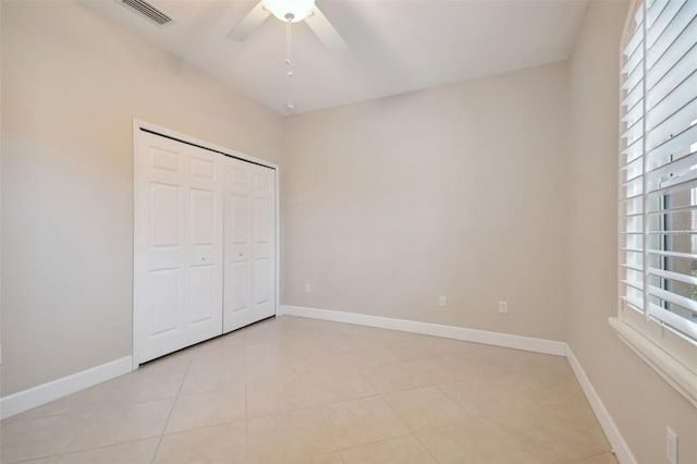 unfurnished bedroom featuring light tile patterned floors, ceiling fan, and a closet