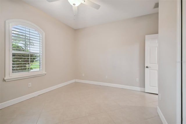 tiled empty room featuring ceiling fan