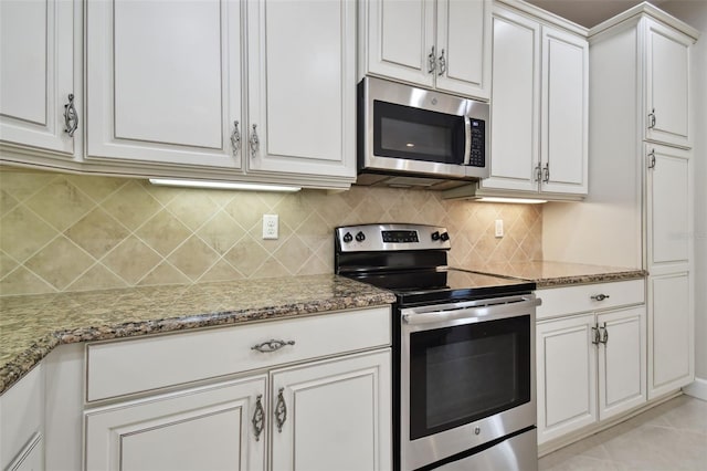 kitchen with stone counters, stainless steel appliances, tasteful backsplash, and white cabinets