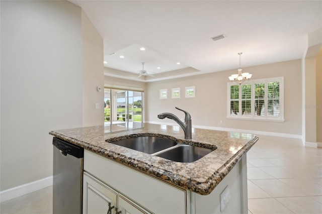 kitchen featuring sink, decorative light fixtures, dishwasher, an island with sink, and stone counters