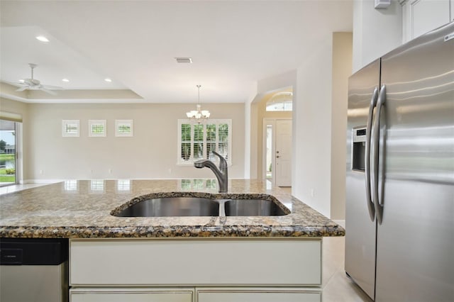 kitchen featuring pendant lighting, white cabinetry, sink, dark stone countertops, and stainless steel appliances