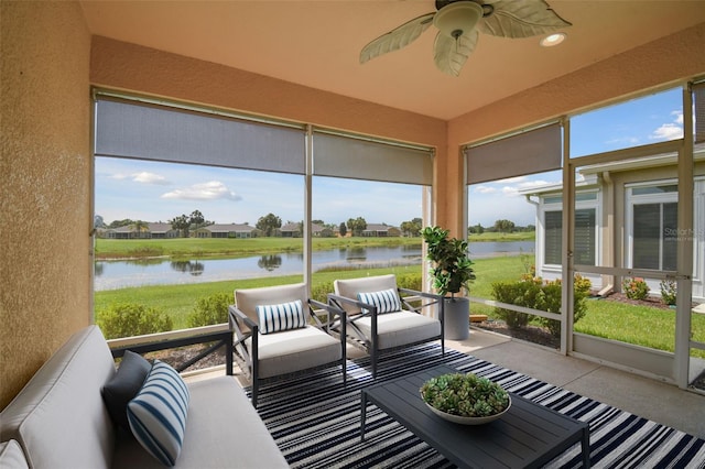 sunroom / solarium featuring a water view and ceiling fan