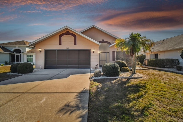 single story home featuring a lawn and a garage