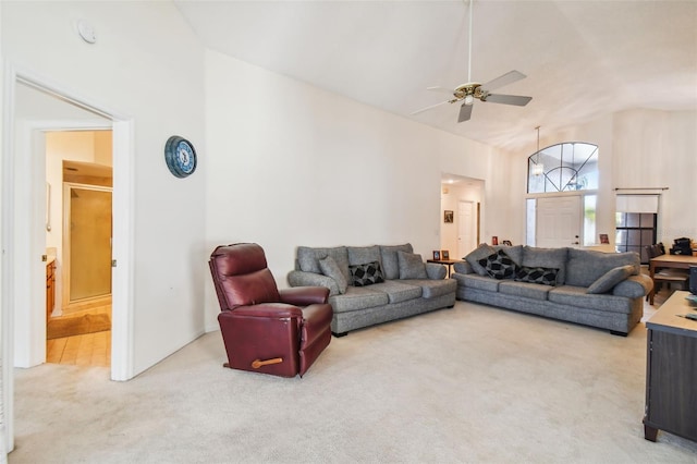 carpeted living room featuring ceiling fan and high vaulted ceiling