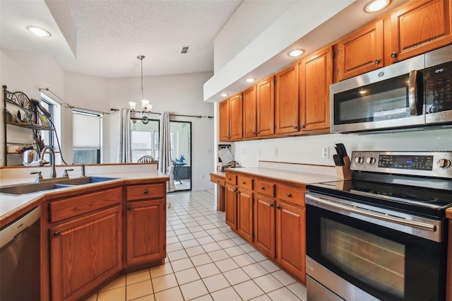 kitchen with decorative light fixtures, a notable chandelier, appliances with stainless steel finishes, sink, and light tile floors