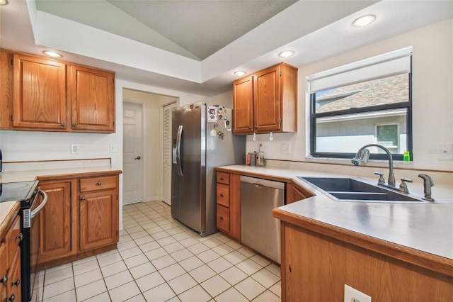 kitchen with light tile flooring, vaulted ceiling, sink, and stainless steel appliances