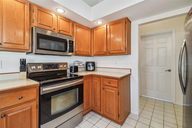 kitchen with light tile floors and appliances with stainless steel finishes