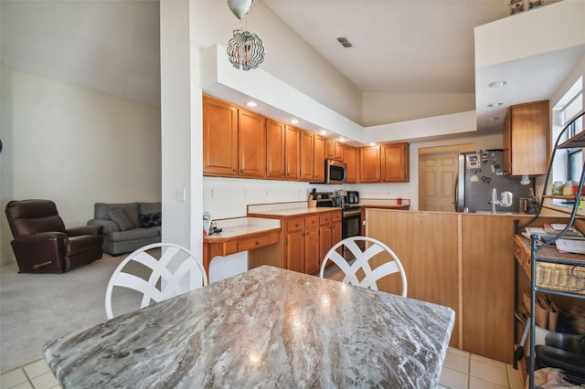 kitchen with light colored carpet, high vaulted ceiling, and appliances with stainless steel finishes