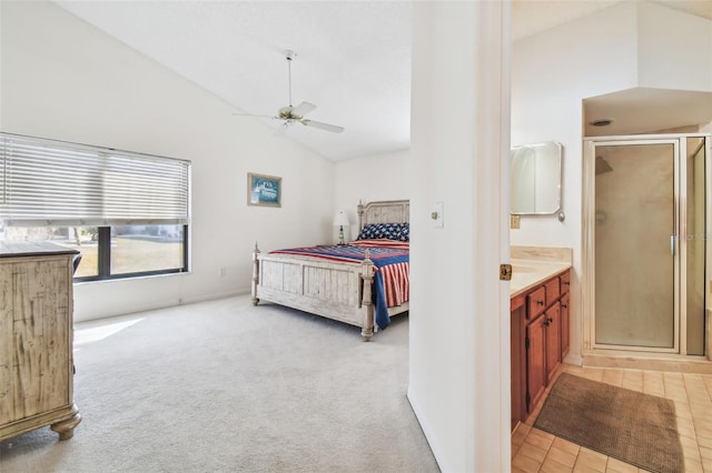 bedroom with high vaulted ceiling, ceiling fan, light colored carpet, and ensuite bathroom