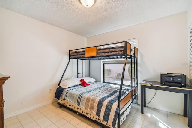 bedroom with a textured ceiling and light tile flooring