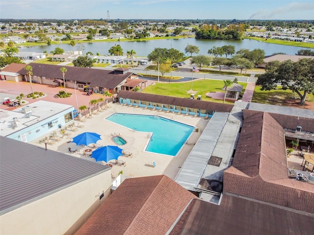 view of swimming pool featuring a water view and a patio