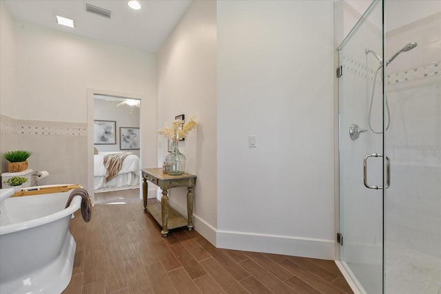 bathroom with hardwood / wood-style floors and shower with separate bathtub