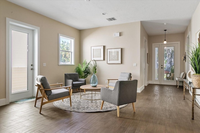 living area with hardwood / wood-style floors and french doors