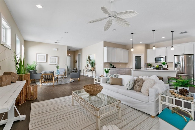 living room featuring sink, ceiling fan, and hardwood / wood-style flooring