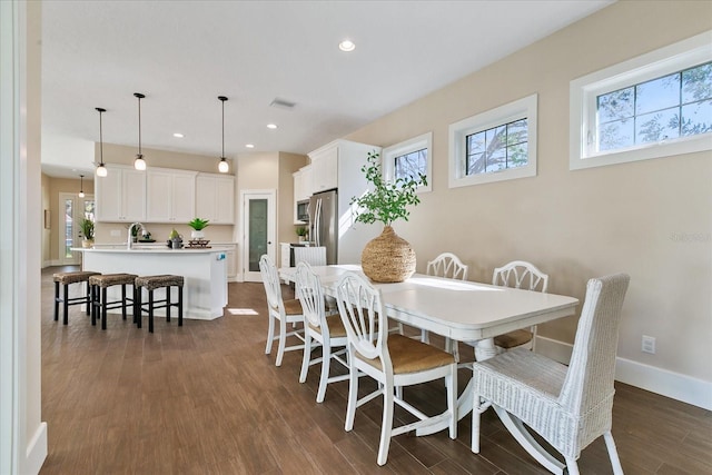 dining space with dark wood-type flooring and sink