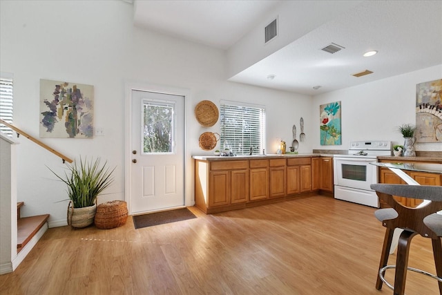 kitchen featuring light hardwood / wood-style flooring, white range with electric stovetop, and sink